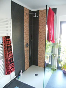 ebenderdiger Duschbereich mit Großflächenfliesen und Mosaikfliesen