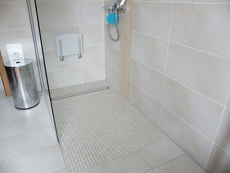 behinderten- und altersgerechte Dusche mit Mosaikboden und Großflächen-Wandfliesen