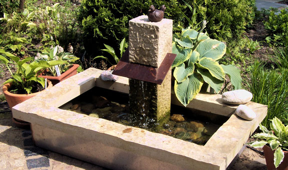 Individuell gestalteter kleiner Brunnen mit Eisenplatte