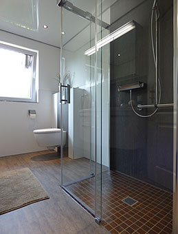 Badezimmergestaltung mit ebenerdiger Dusche und Ganzglaswänden