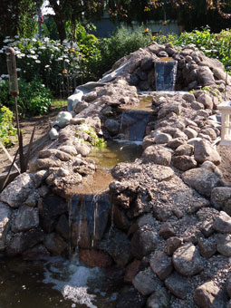 dekorative Mauer aus Naturstein mit kleinem Bachlauf