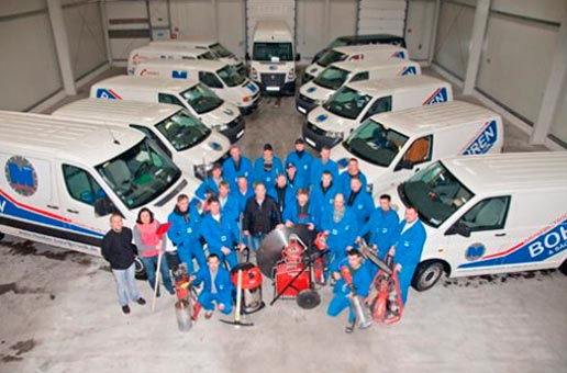 Mitarbeiterteam sowie Firmenfahrzeuge Mitarbeiterteam sowie Firmenfahrzeuge