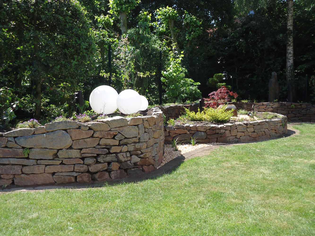 Trockenmauer und stilvolle Gartenbeleuchtung