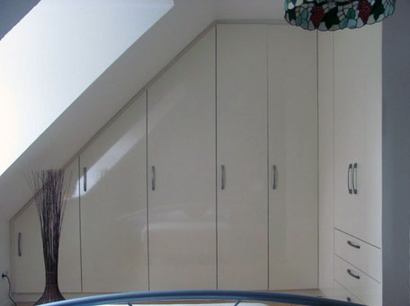 Einbauschrank Hochglanz Vanille in Dachschräge über Eck eingebaut. Einbauschrank Hochglanz Vanille in Dachschräge über Eck eingebaut.