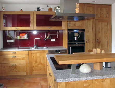 Landhausküche Front in Eiche astig massiv - gebürstet und geölt mit effektvollen roten Hochlan-Paneelen und Glas