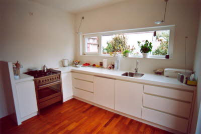 eine Küche mit Unterschränken und Arbeitsplatte und einem großen Fenster für viel Licht